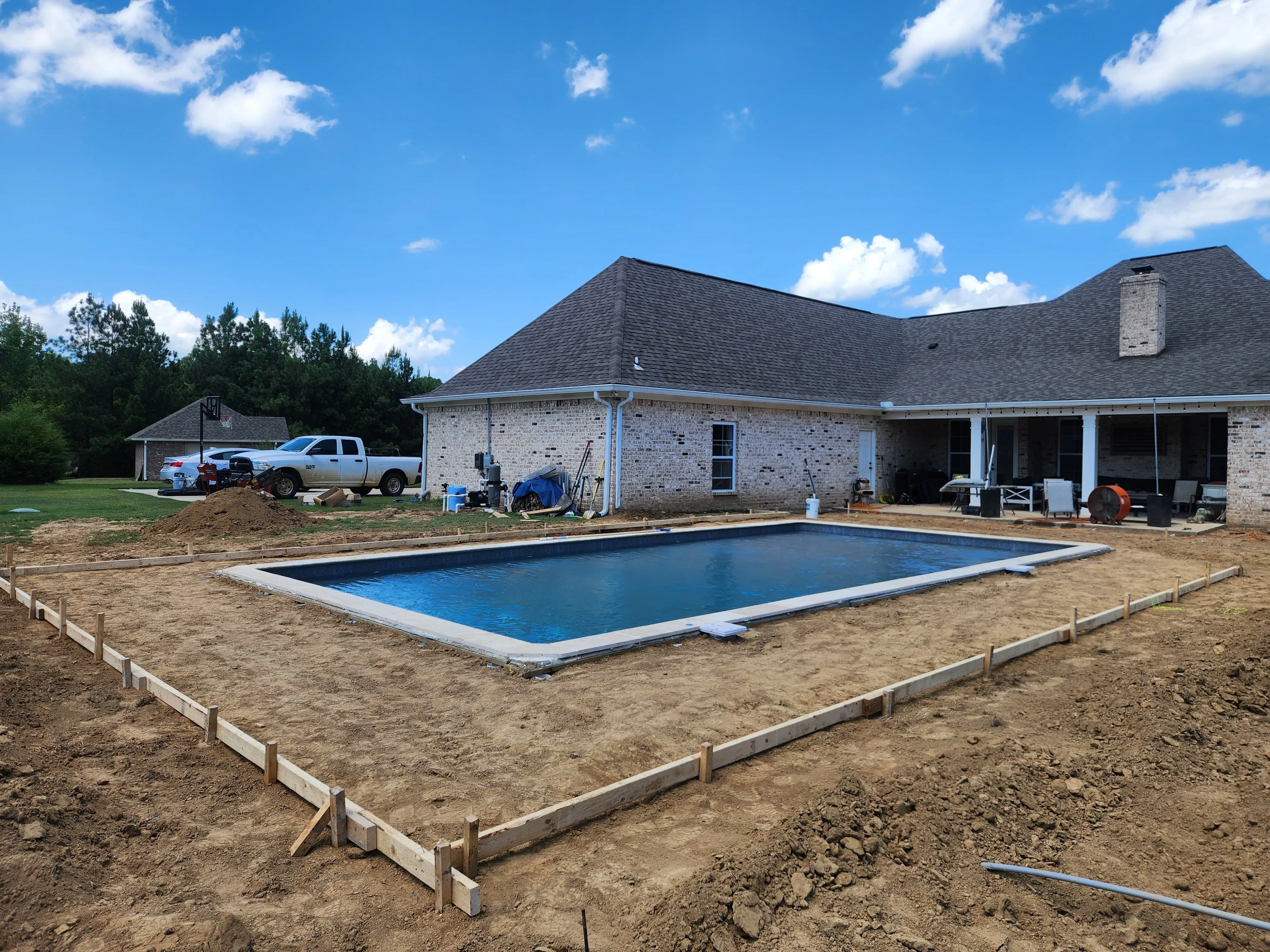 Backyard concrete work in progress near pool excavation, Pearl, MS