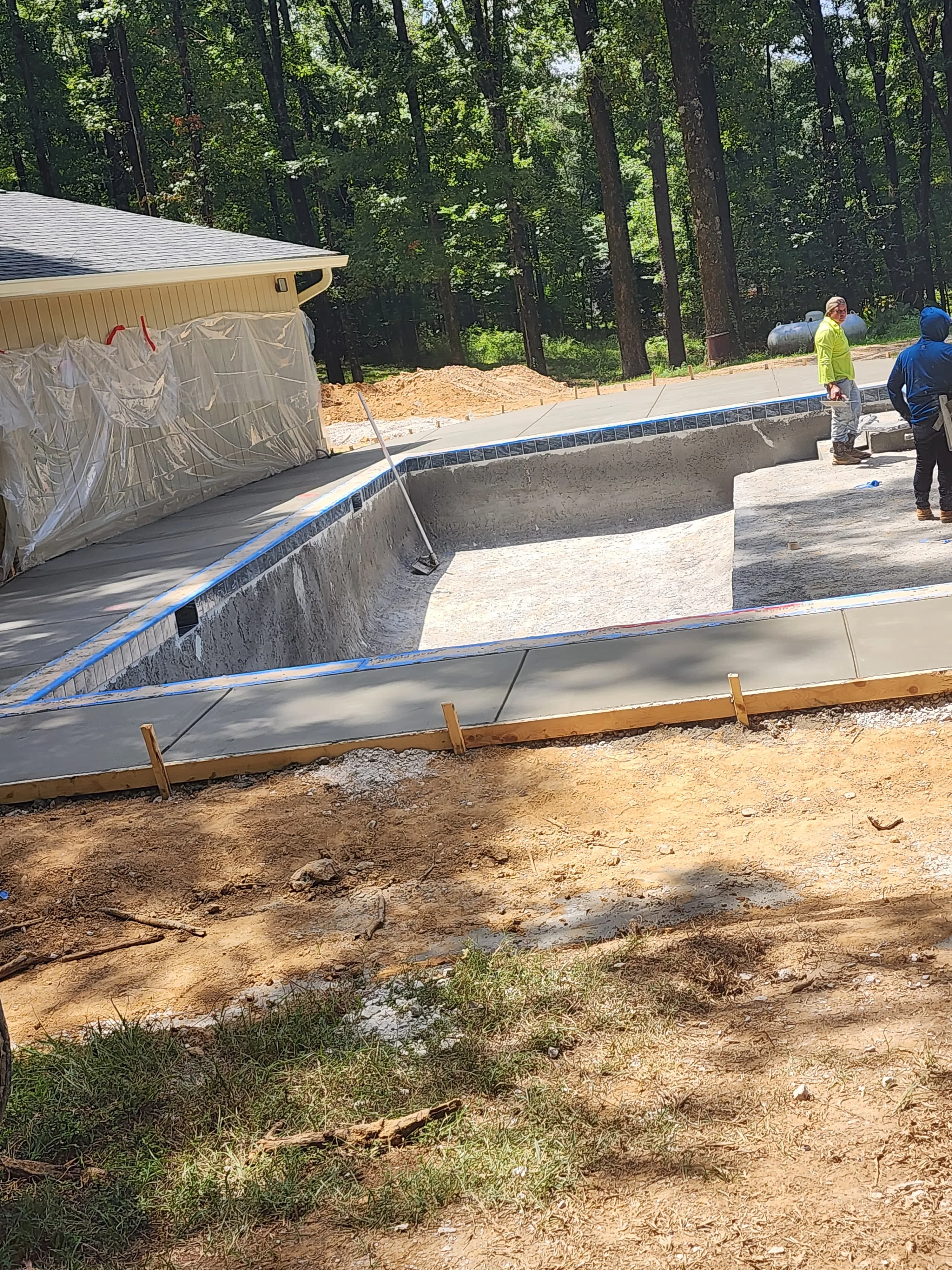 Concrete pool deck being poured and screeded, Pearl, MS